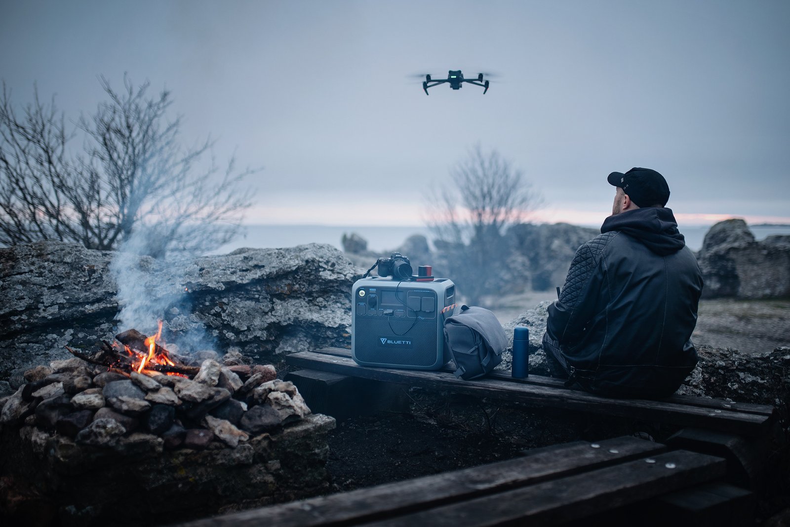 Man styr drönare vid en lägereld med Bluetti batteribank i Folhammar, Gotland.
