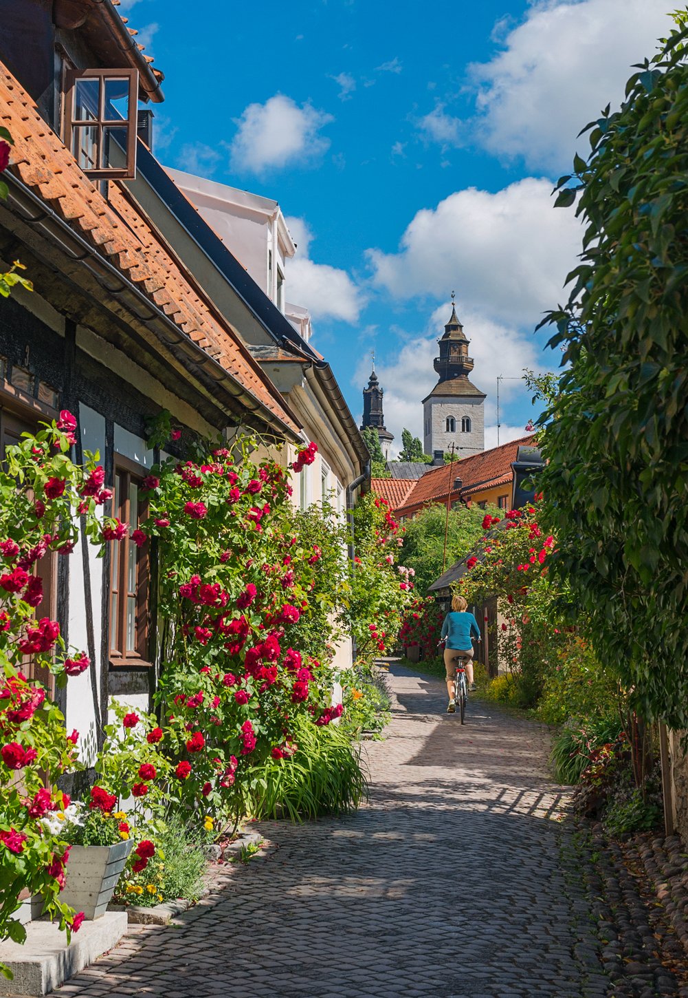 Familj- & parfoto A woman bicycling towards St Maria
