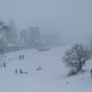 Barn som åker pulka i kraftigt snöfall vid Ringmuren i Nordergravar, Visby.