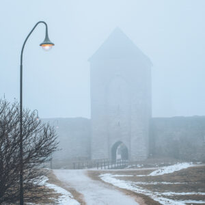 Dimhöljda Dalmansporten och ringmuren i Visby under en stilla vinterdag