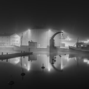 Dimma över Visby hamn en stilla natt med båtar och ljus som speglas i vattnet