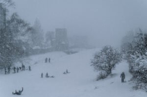 Barn som åker pulka i kraftigt snöfall vid Ringmuren i Nordergravar, Visby.