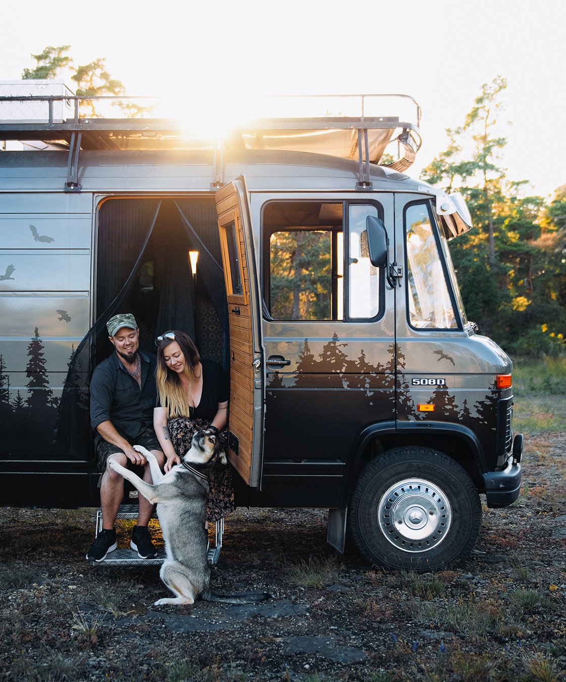 Katja sitter tillsammans med sin sambo Björn och hunden Louie utanför deras Mercedes campervan Beelzebus i kvällssolen på Gotland.