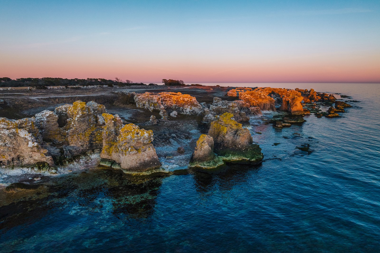 Drönarbild av raukarna vid Holmhällar i Gotland under kvällens sista solljus